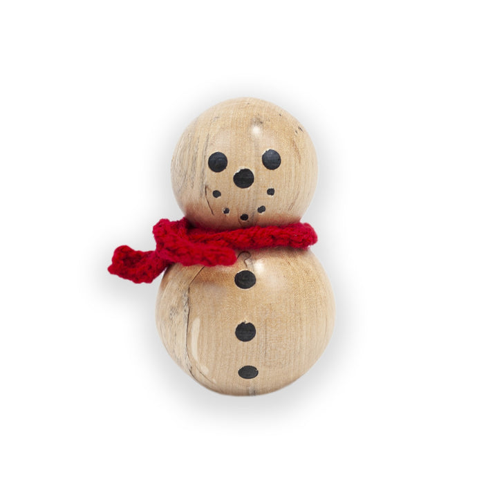 一个小木头雪人，有着煤黑色的眼睛和一条鲜红色的针织围巾