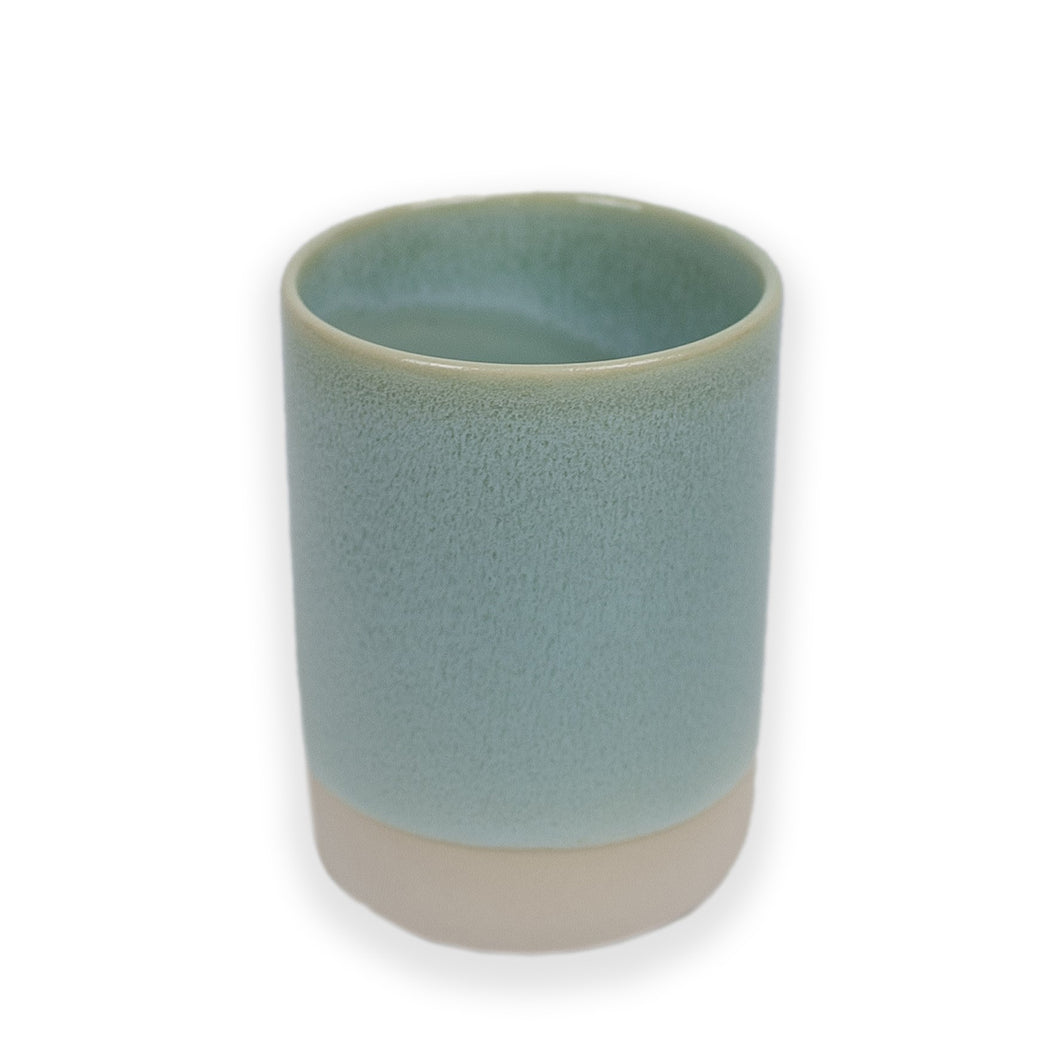 A porcelain cup without a handle, glazed in pale pink with splodges of blue. Handmade by Studio Arhoj in Copenhangengen. 